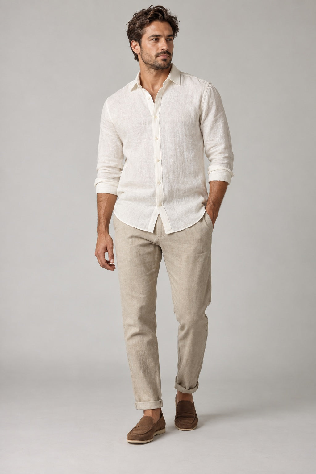 Male model wearing relaxed summer shirt in white on a neutral studio background