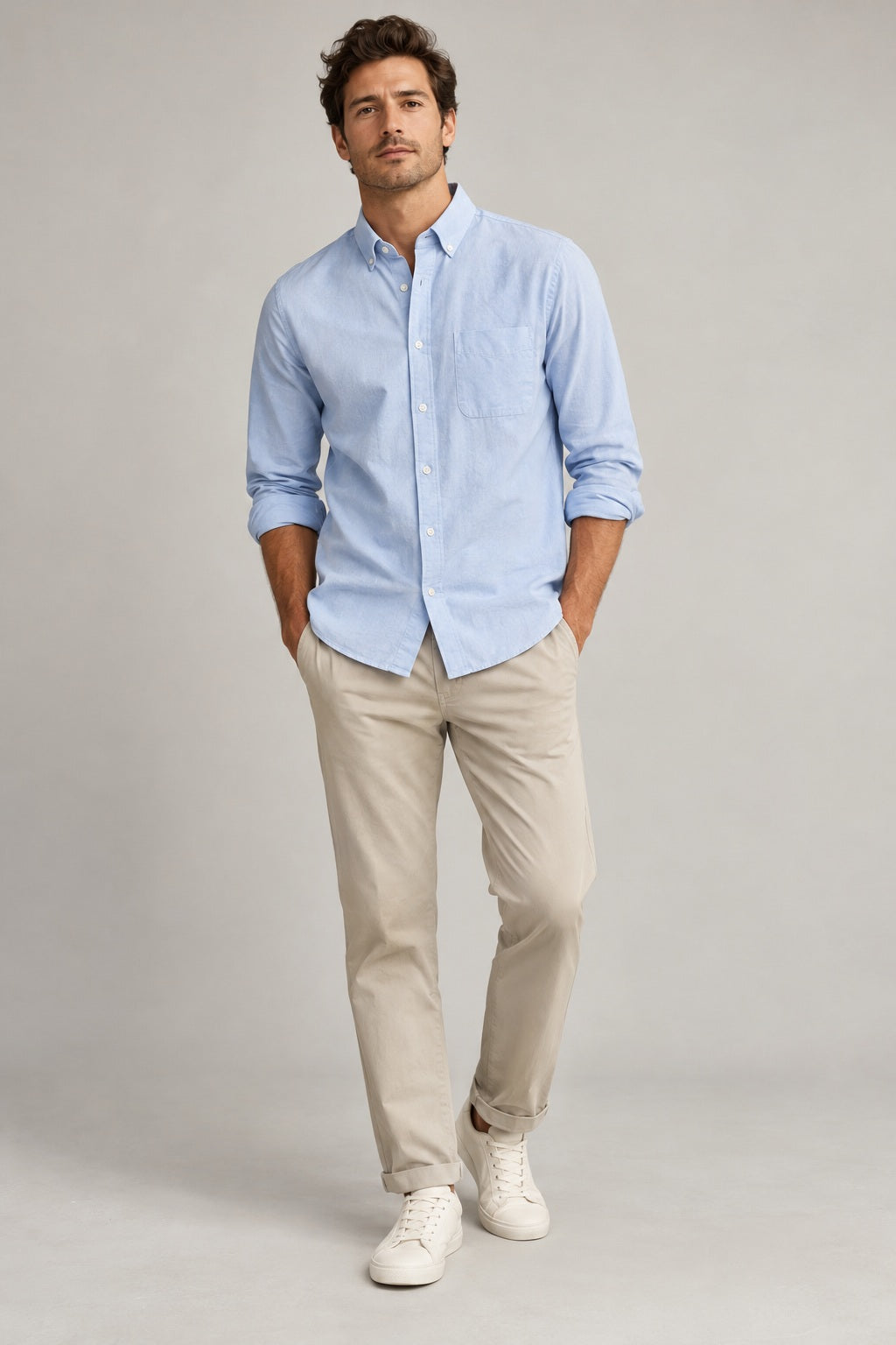 Male model wearing relaxed oxford shirt in light blue on a neutral studio background